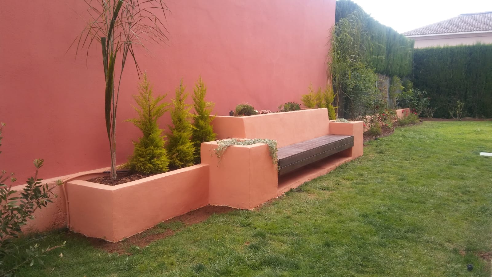 Obra terminada: Estructura de obra, jardineras y banco integrados en el muro perimetral.